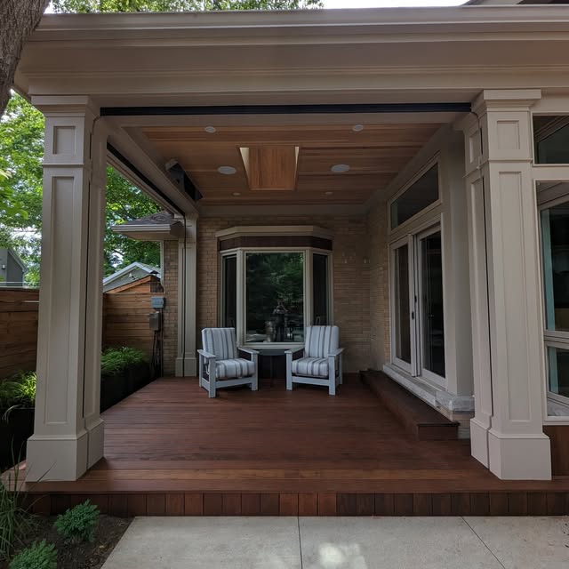 A custom covered porch with a warm wood ceiling and deck, opening onto a garden